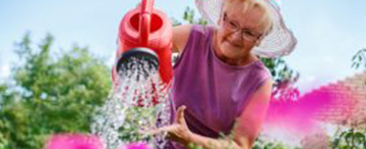 retired woman watering flowers