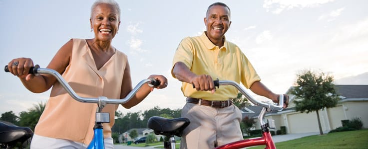 retired couple happily riding bikes