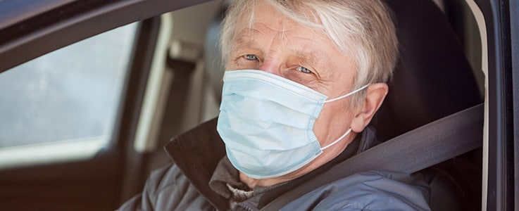 man in car wearing medical mask