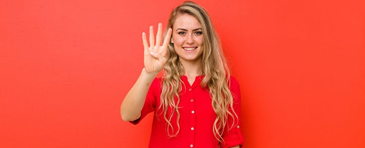 smiling woman holding up four fingers