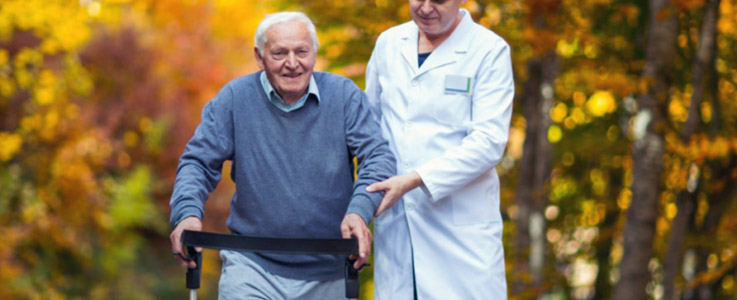 elderly man walking with doctor