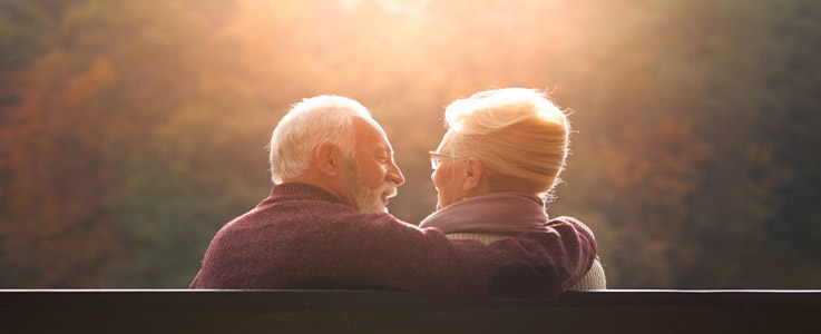 retired couple embracing at sunset