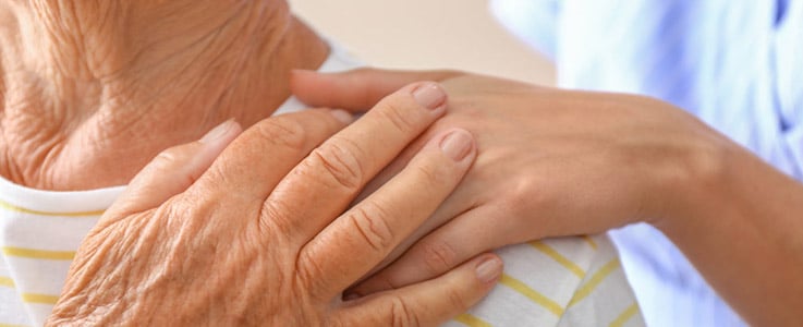 nurse holding hands with elderly patient