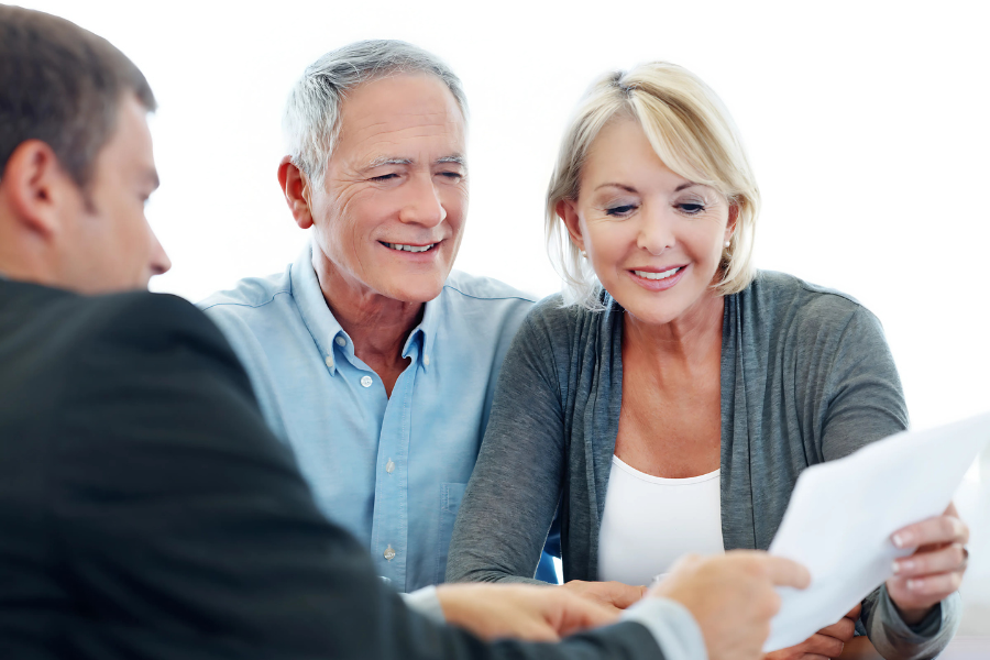 Senior couple meeting with their financial advisor to review their retirement documents