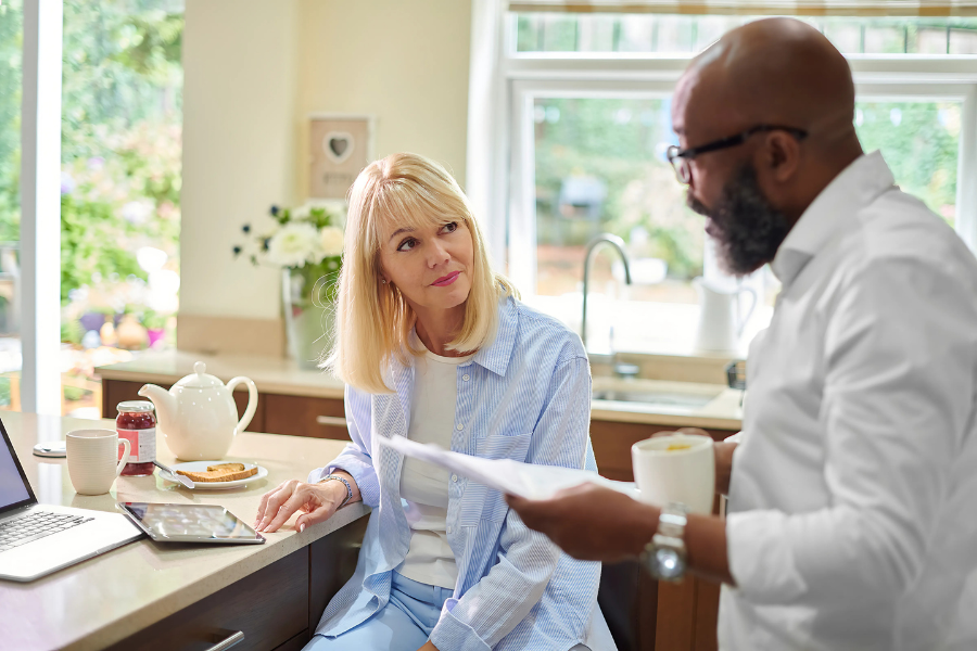 A couple discussing over coffee their options for lowering longevity risks to their retirement.