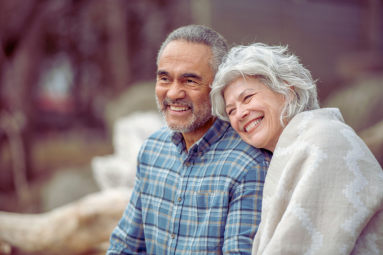 happy retired couple sitting together outside
