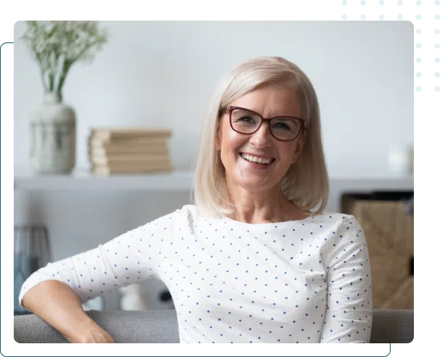a older woman wearing glasses looking happy